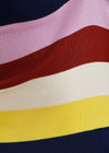 Close-up of a sweater with colorful horizontal stripes in pink, red, white, yellow, and navy.