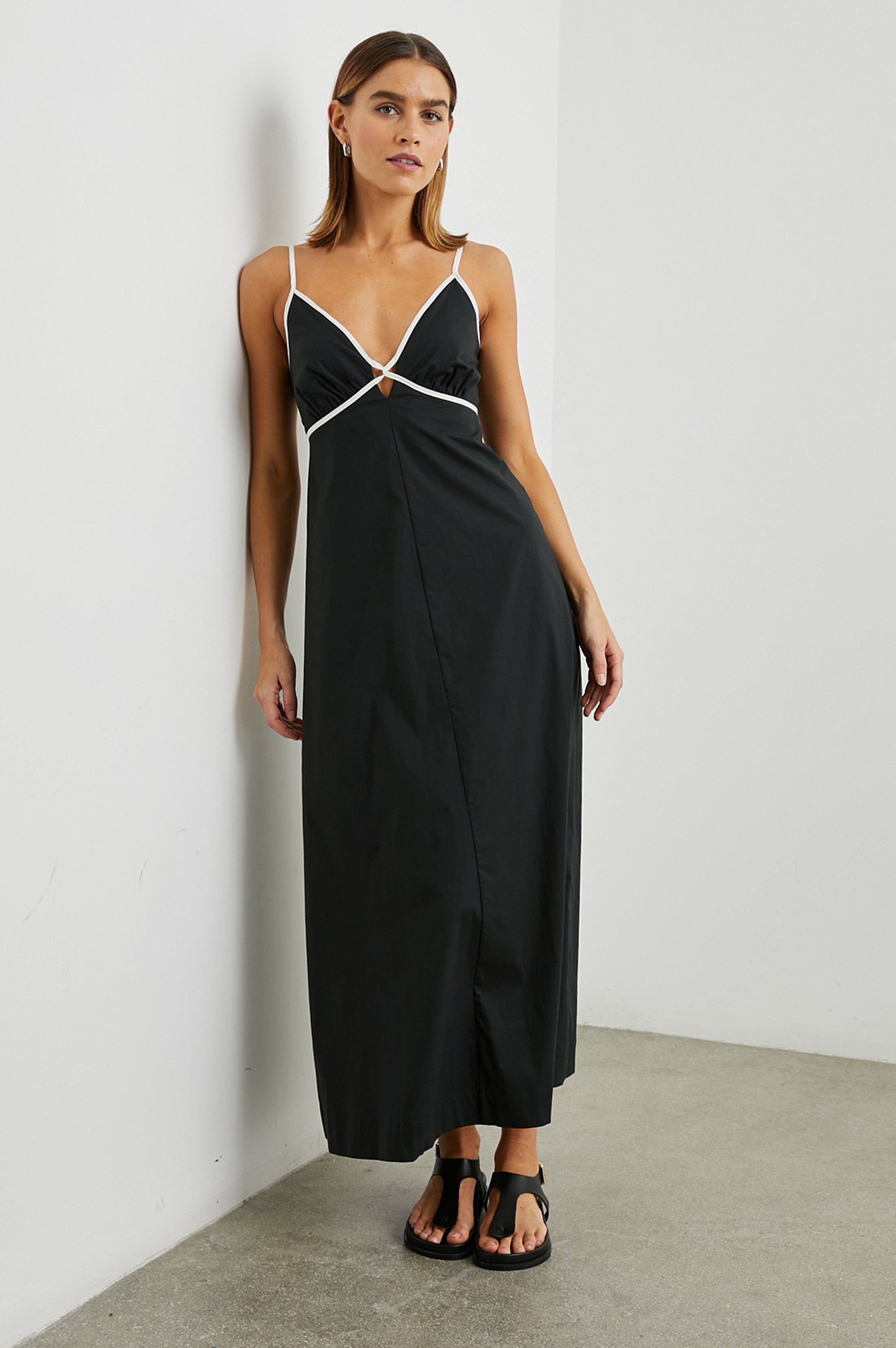 Black midi length dress with white trim at the bust and straps