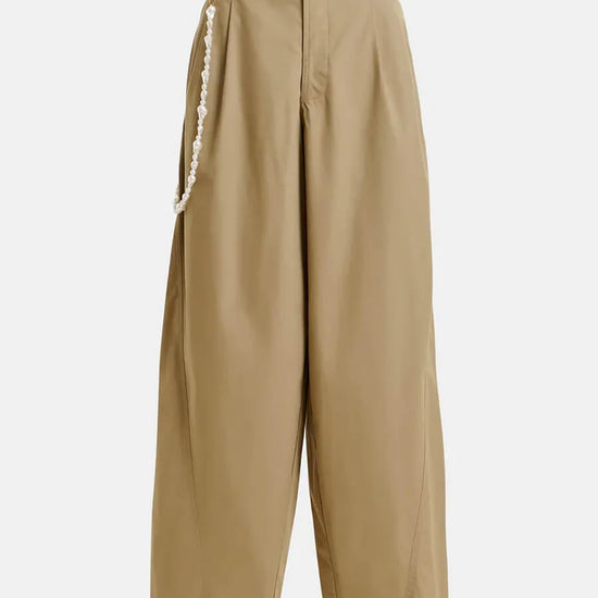 Beige pants with a decorative white trim on a white background