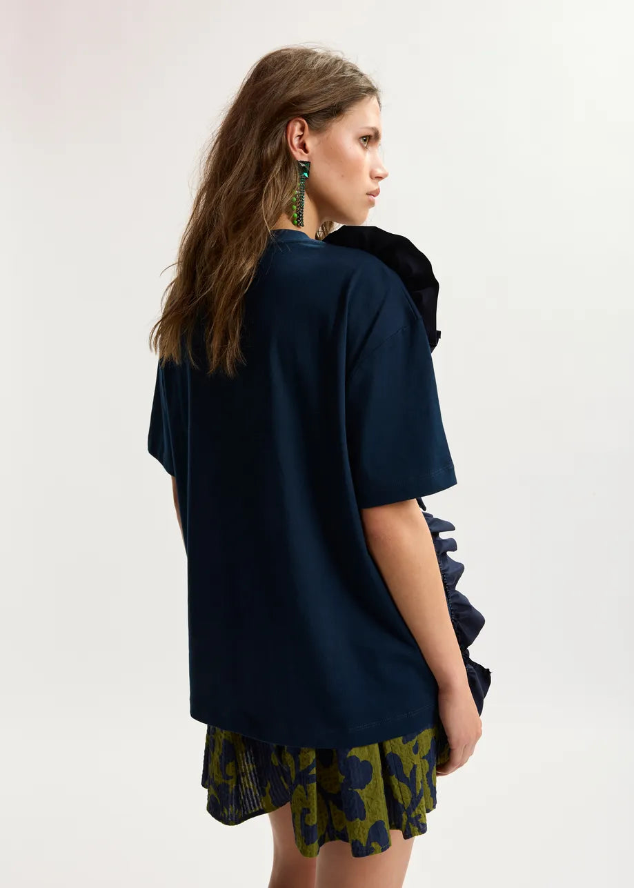 Woman wearing a dark blue top and patterned skirt on a white background