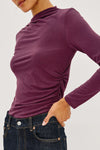 close up image of a model wearing a burgundy coloured mock neck long sleevel top
