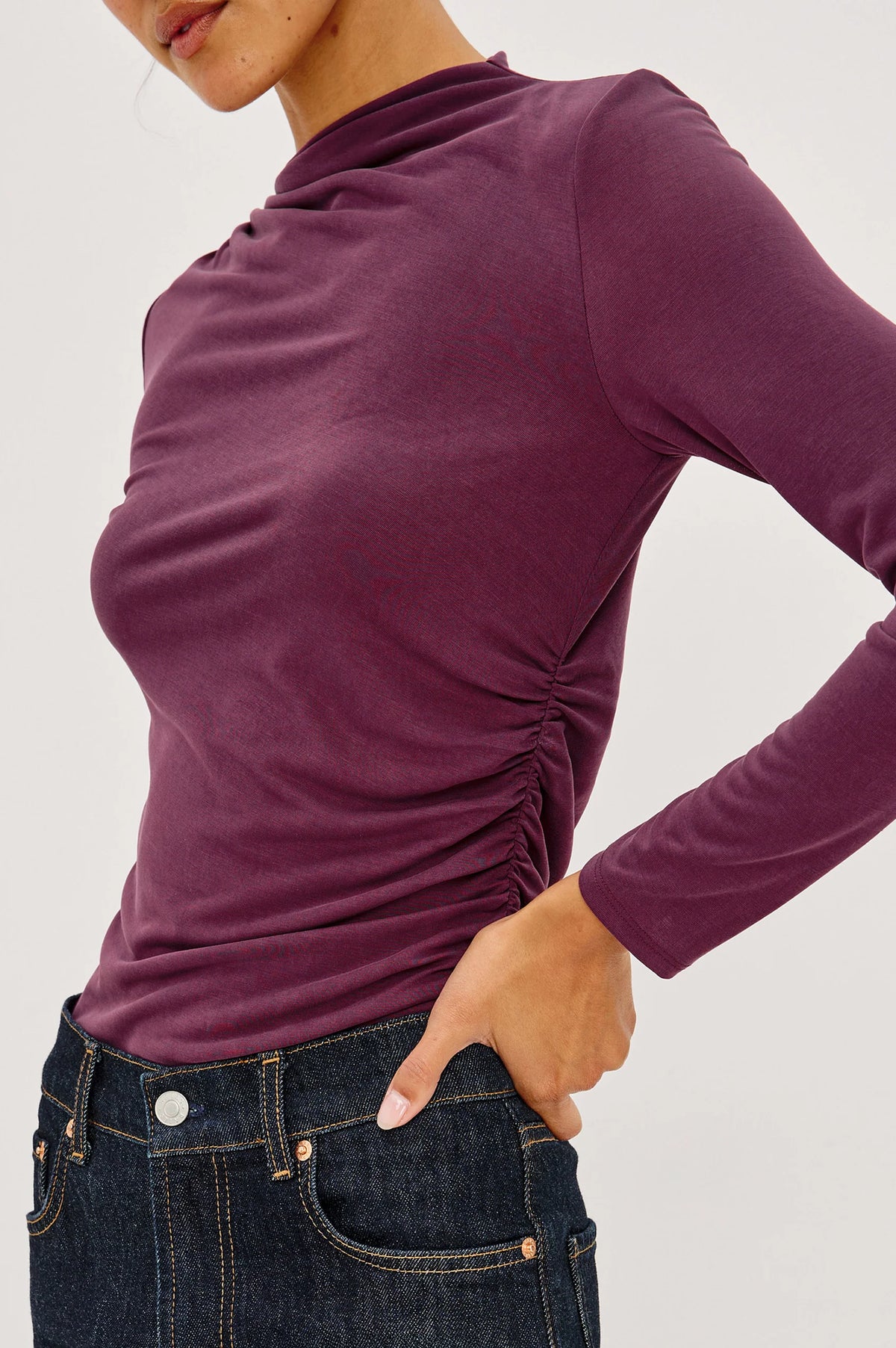 close up image of a model wearing a burgundy coloured mock neck long sleevel top