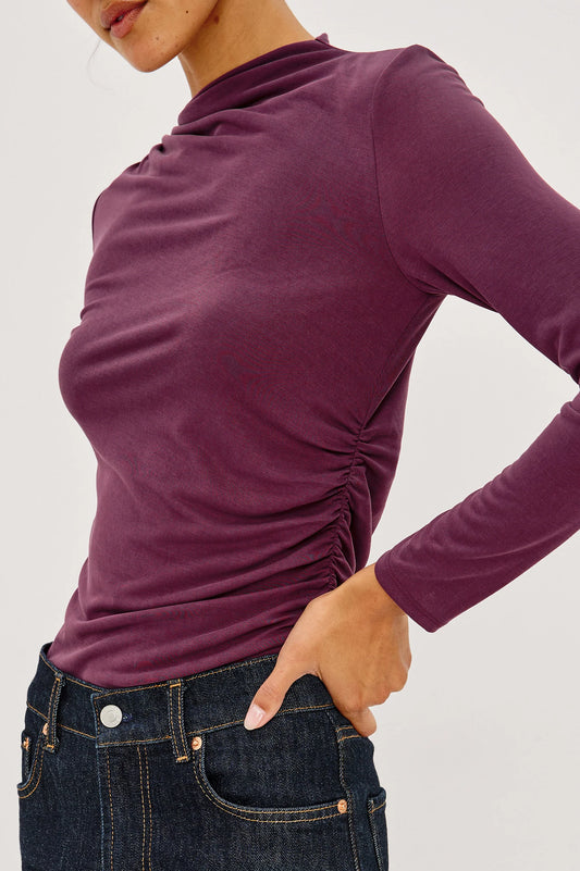 close up image of a model wearing a burgundy coloured mock neck long sleevel top