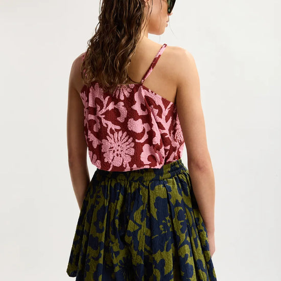 Woman wearing a patterned top and skirt on a white background