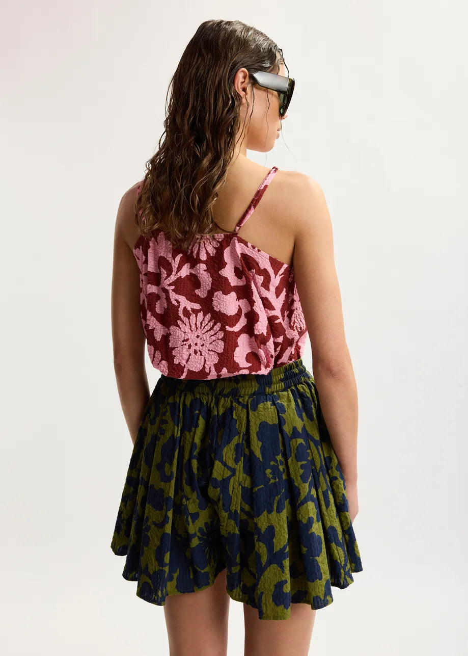 Woman wearing a patterned top and skirt on a white background