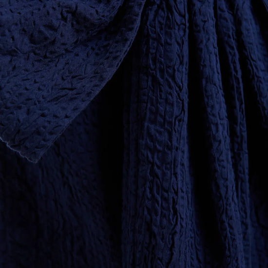 Close-up of textured navy fabric with a focus on pattern and texture.