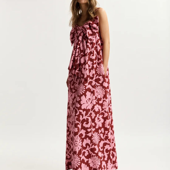 Woman wearing a pink floral dress on a white background