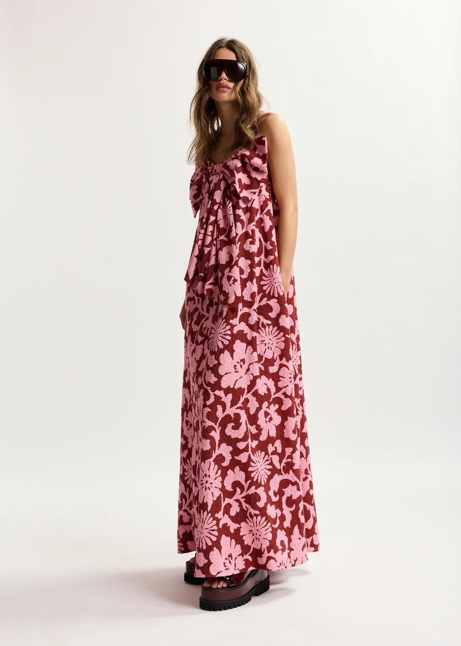 Woman wearing a pink floral dress on a white background