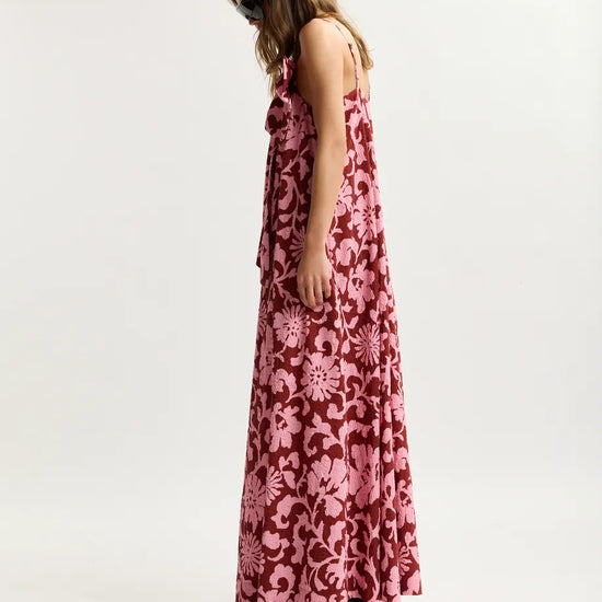 Woman wearing a pink floral dress on a white background