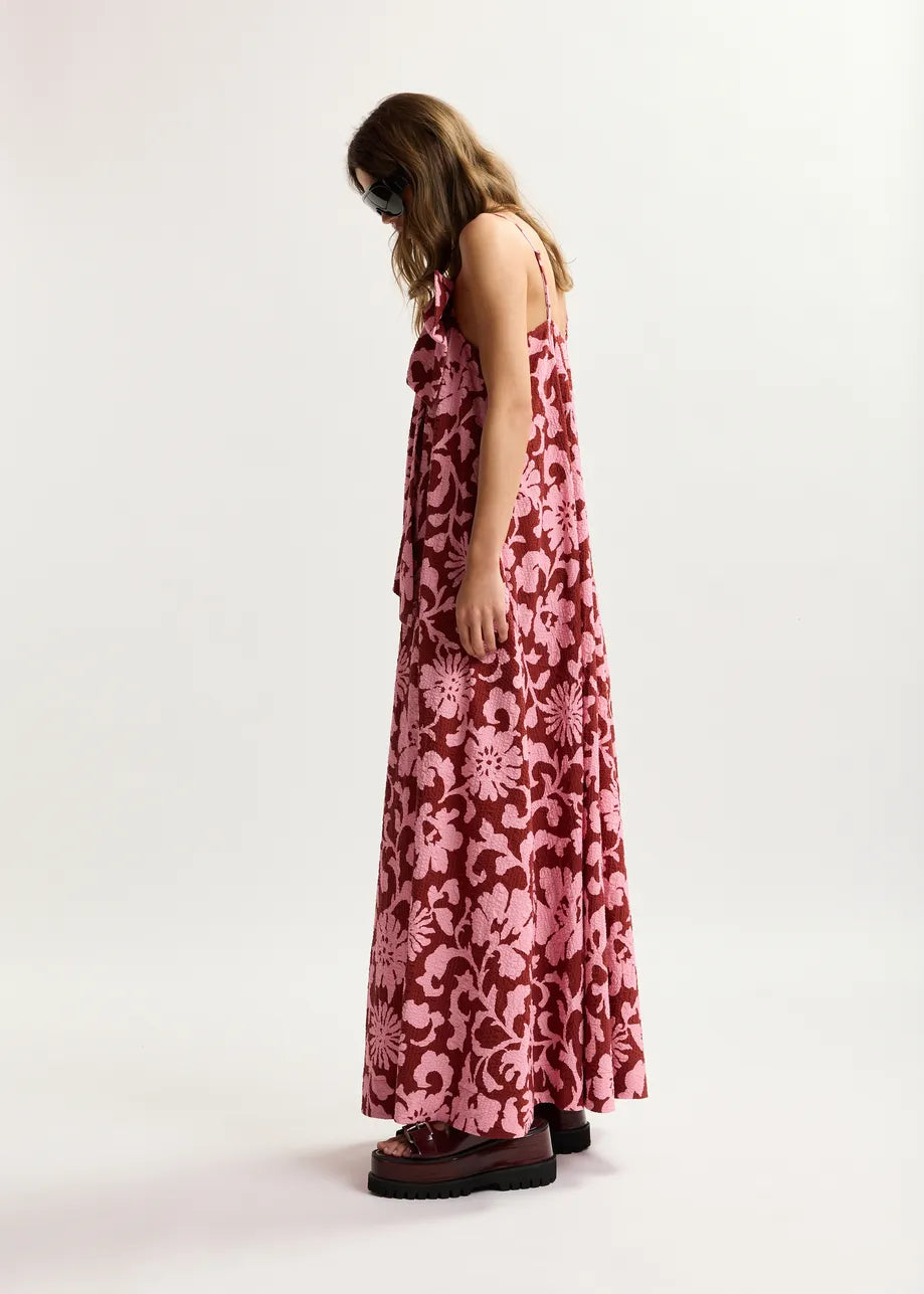Woman wearing a pink floral dress on a white background