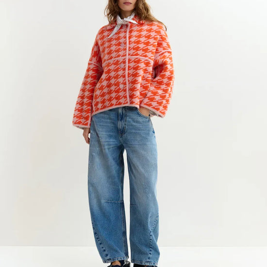 houndstooth red textured jacket with pink background  model 