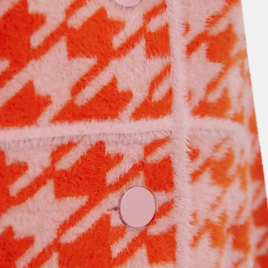houndstooth red textured jacket with pink background close up