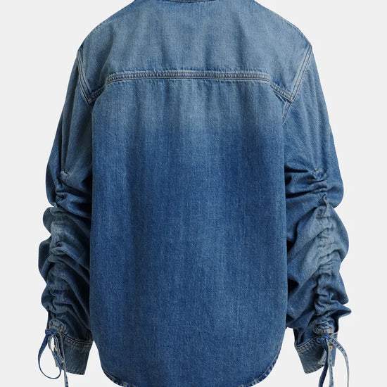 Blue denim shirt with long sleeves on a white background