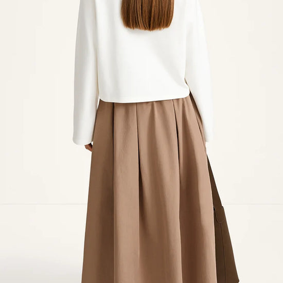 Person wearing a white top and brown skirt on a white background
