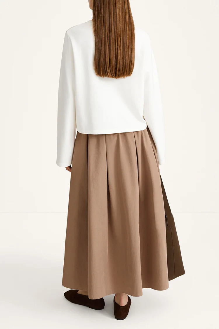 Person wearing a white top and brown skirt on a white background