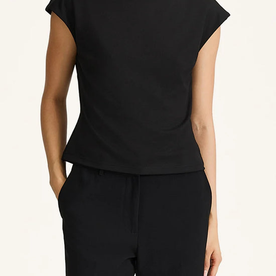 Person wearing a black top and black pants on a white background