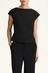 Person wearing a black top and black pants on a white background