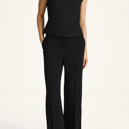 Person wearing a black outfit with a plain background