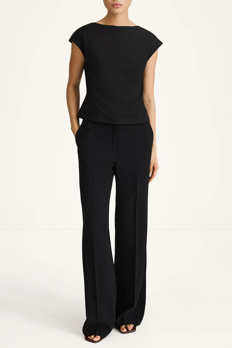 Person wearing a black outfit with a plain background