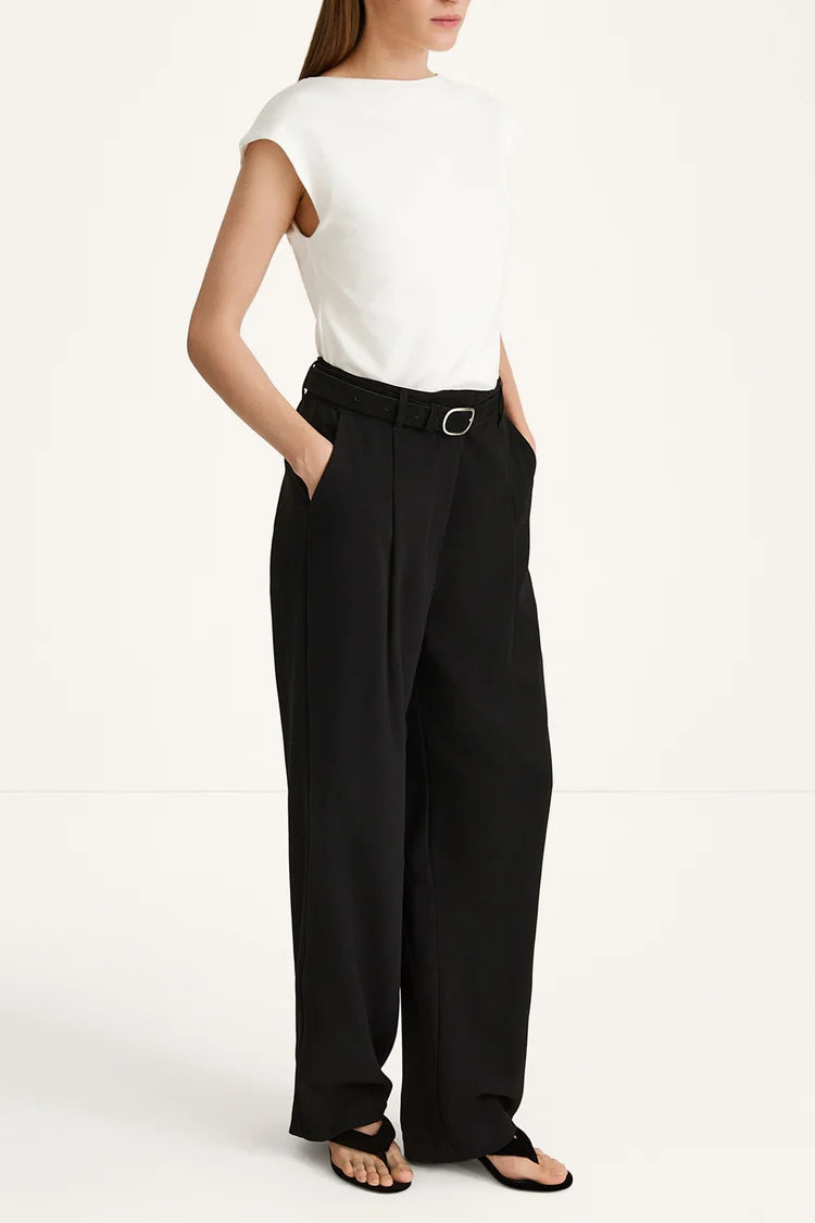 Person wearing a white top and black high-waisted pants on a white background