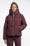Woman wearing a maroon puffer jacket on a white background