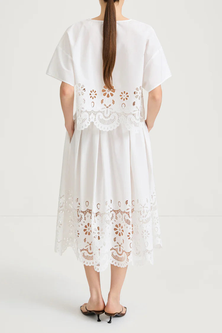 White dress with floral lace details on a white background