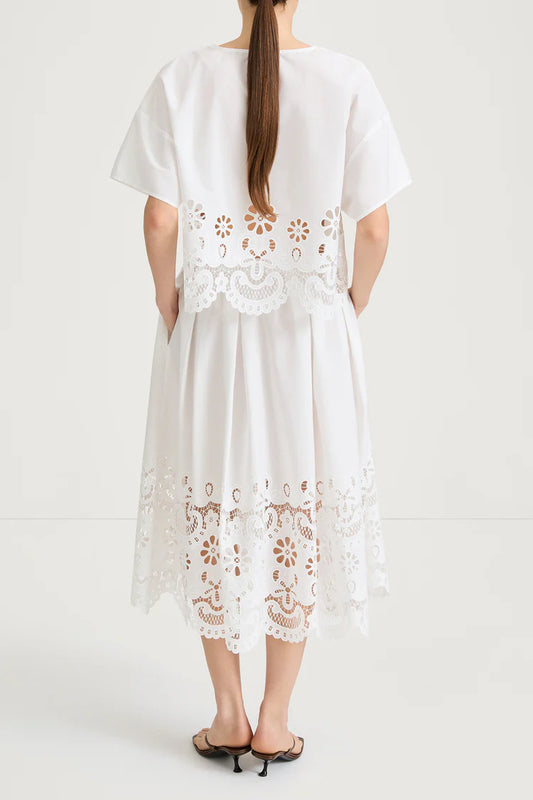 White dress with floral lace details on a white background