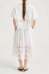 White top and skirt with floral lace details on a white background