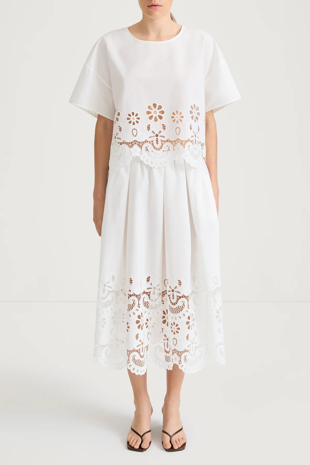 White dress with floral lace details on a white background