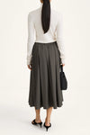woman wearing grey skirt and white long sleeve top on white background