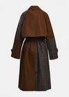 A color-blocked mid-length coat shown from the back, featuring a solid brown upper back and cape-like yoke, dark gray plaid sleeves, and a matching dark gray plaid skirt with a thin brown waist belt.