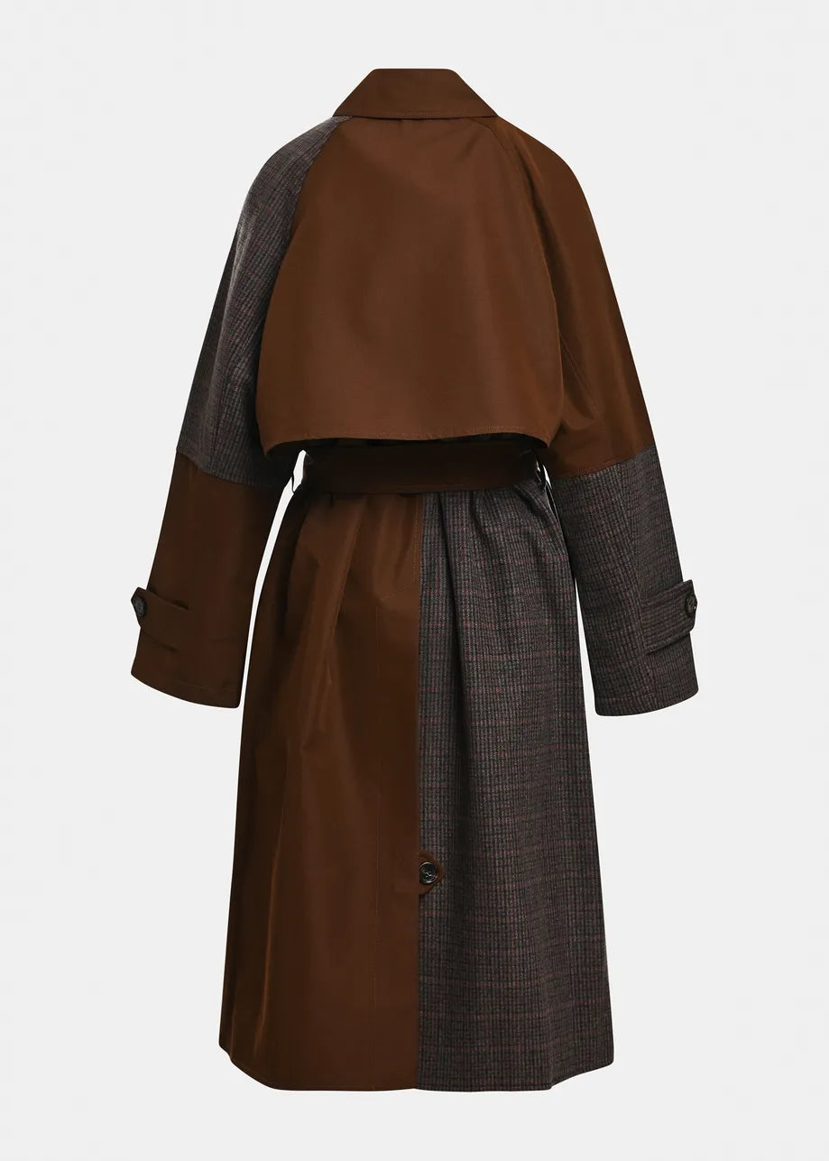A color-blocked mid-length coat shown from the back, featuring a solid brown upper back and cape-like yoke, dark gray plaid sleeves, and a matching dark gray plaid skirt with a thin brown waist belt.