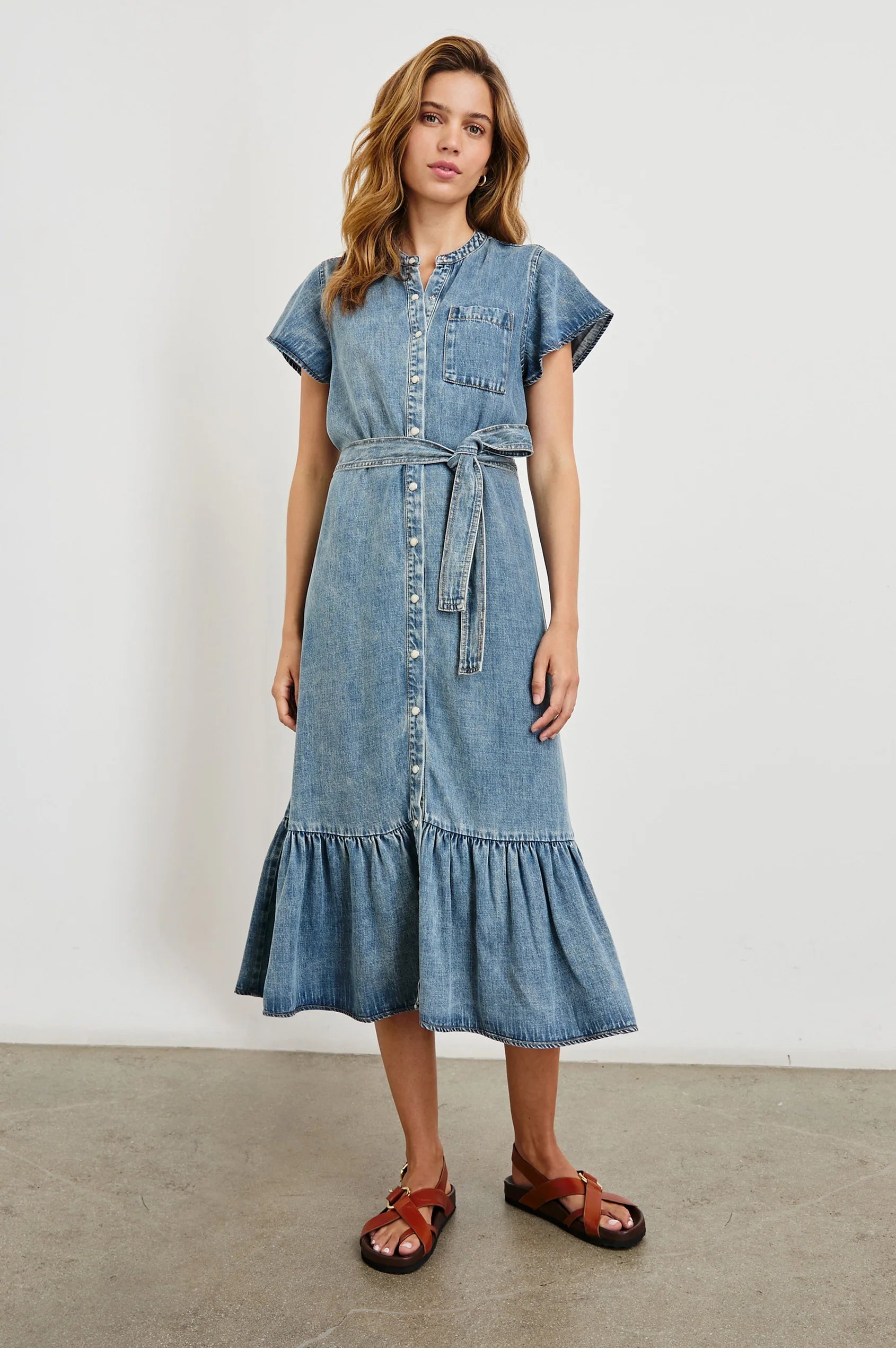 Woman wearing a denim dress with a white background