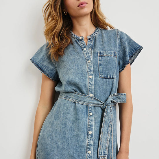 Woman wearing a denim dress against a white background