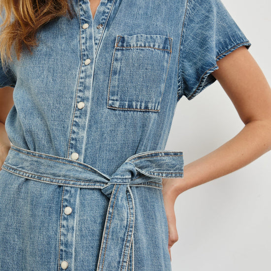 Denim dress with a belt on a plain background