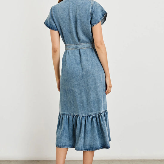 Woman wearing a blue denim dress against a white background