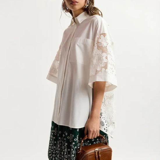 model wearing white lace shirt on plain background