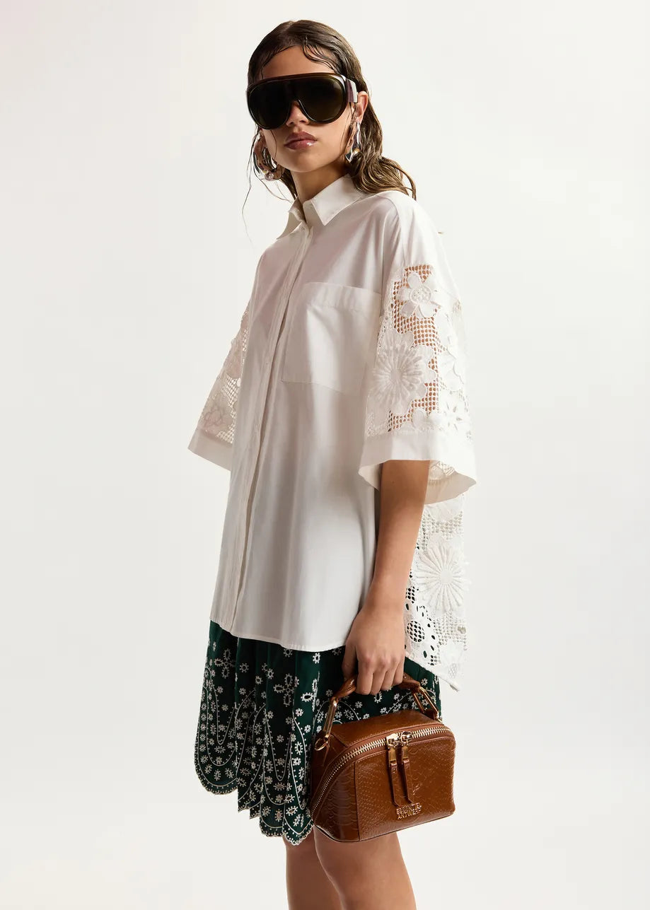 model wearing white lace shirt on plain background