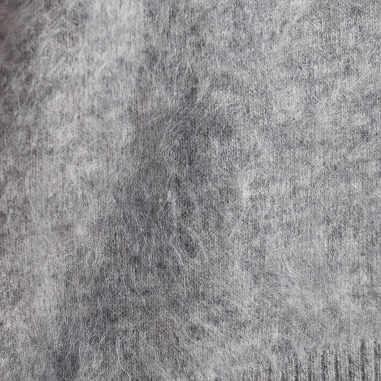 Close-up of a gray knit fabric with a ribbed cuff at the bottom.