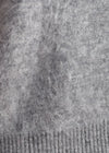 Close-up of a gray knit fabric with a ribbed cuff at the bottom.