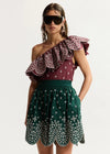 model wearing green skirt on plain background