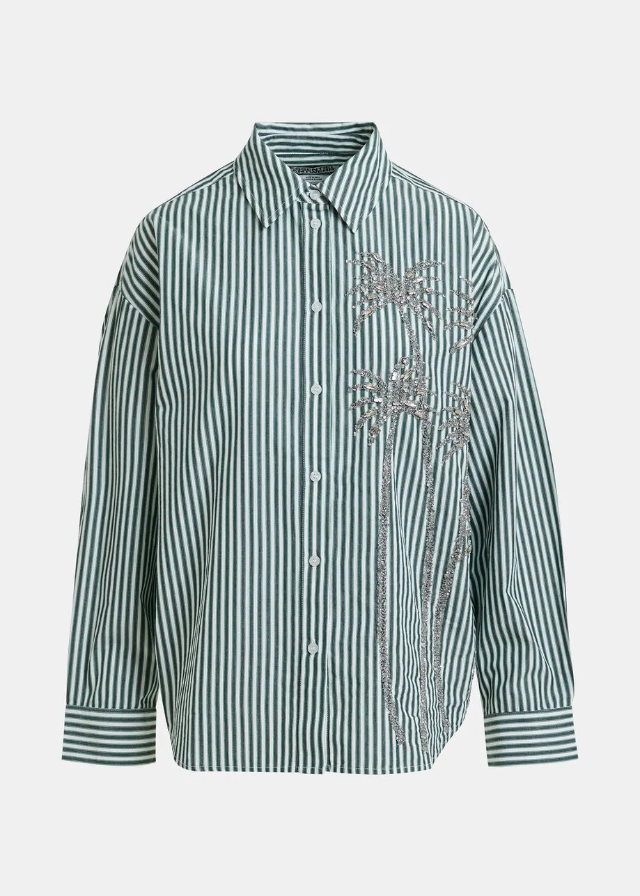 Green and white striped shirt with floral embroidery on a light gray background