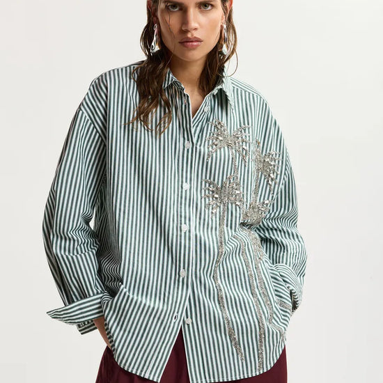 Model wearing a green stripe shirt with embellishment 
