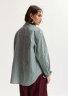 model wearing green stripe shirt shot from the rear