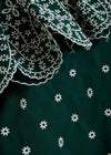 Close-up of green fabric with white embroidery patterns