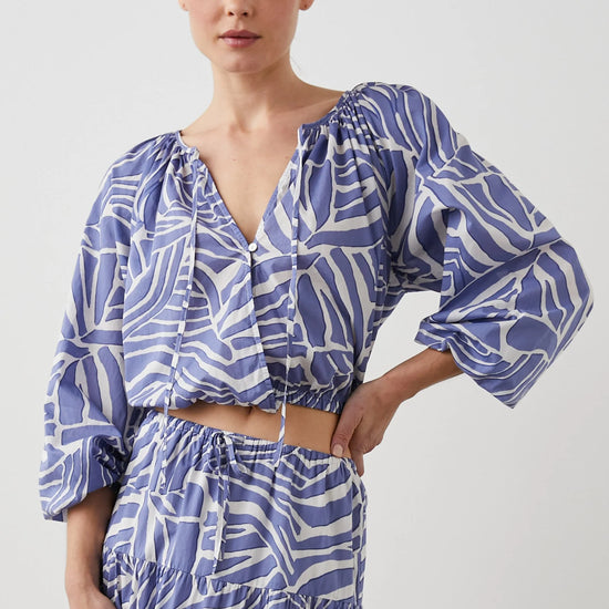 Cropped cross over top with notch neck and long full sleeves with elasticated sleeves in white and blue geometric pattern