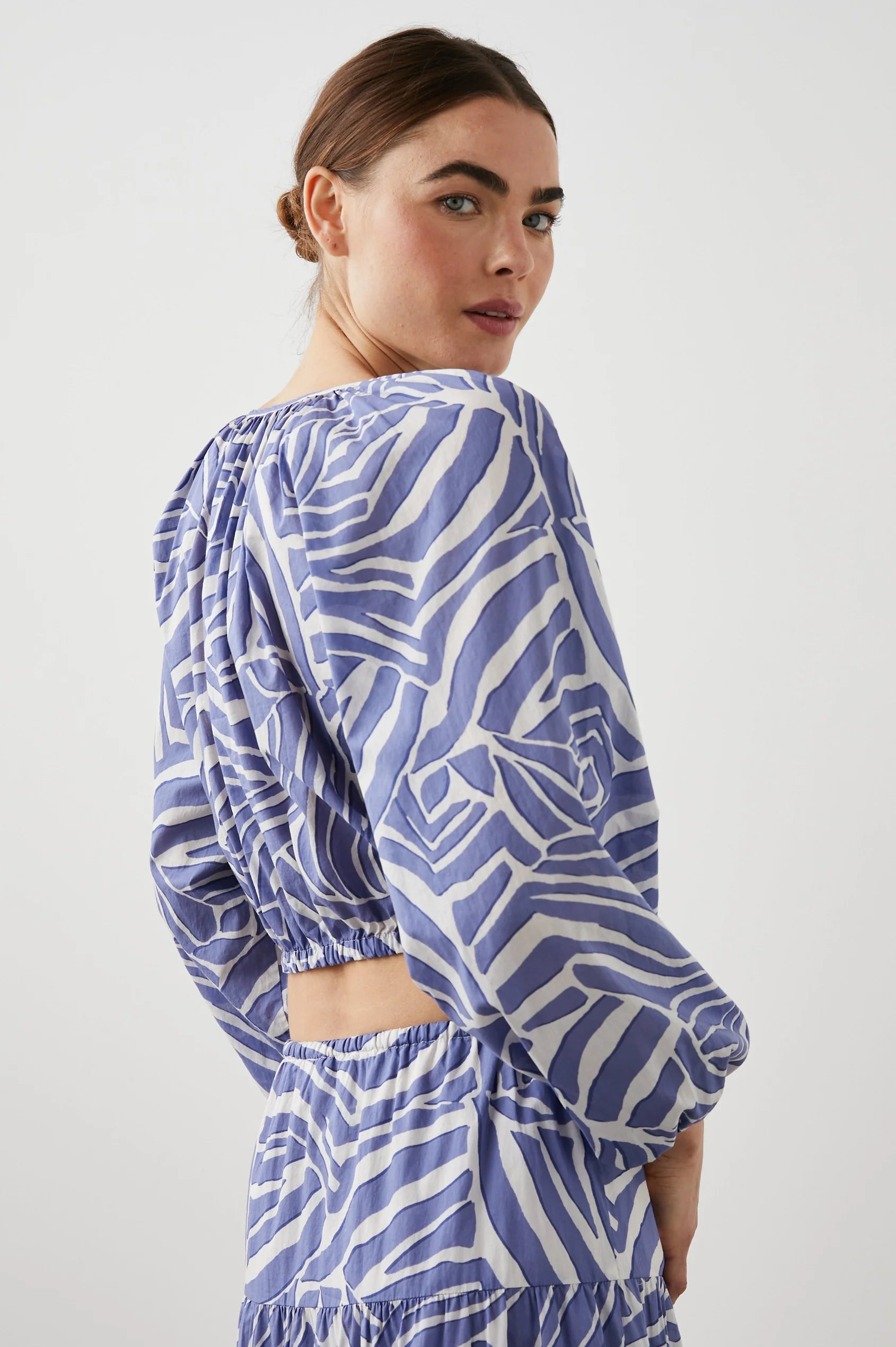 Cropped cross over top with notch neck and long full sleeves with elasticated sleeves in white and blue geometric pattern