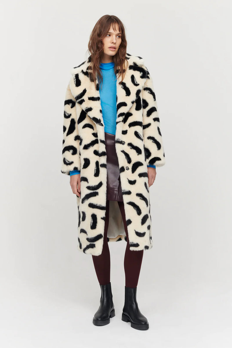 Long faux fur ecru coat with V neckline and notch lapel / collar with popper fastening and black paintbrush all over design