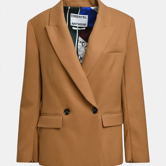 A camel brown double-breasted blazer with notched lapels and flap pockets, shown flat against a light gray background. The inner collar label shows the brand 'Essentiel Antwerp'.
