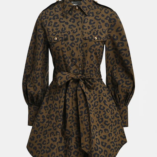 A leopard print shirt dress in brown and black, featuring a collar, button front, flap chest pockets, and a matching waist tie, shown against a light gray background.